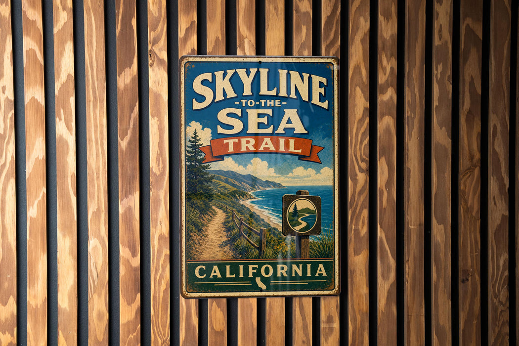 A vintage-style metal sign with the text "SKYLINE TO THE SEA TRAIL" and "CALIFORNIA" is displayed on a wooden wall.