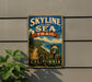 A vintage-style metal sign with the text "SKYLINE TO THE SEA TRAIL" and a scenic illustration of a coastal path leading to a beach, with the word "CALIFORNIA" below.