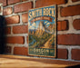 A vintage-style metal sign for the Smith Rock Summit Trail in Oregon, featuring a scenic mountain landscape with a winding trail.