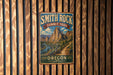 A vintage metal sign for the Smith Rock Summit Trail in Oregon, featuring a scenic mountain landscape.