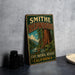 A vintage-style metal sign for the Smithe Redwoods State Natural Reserve in California, featuring an illustration of a forest and a river.