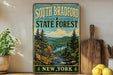 A vintage-style sign for South Bradford State Forest in New York, featuring a scenic landscape with pine trees, mountains, and a river.