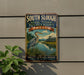 A vintage-style metal sign for the South Slough National Estuarine Research Reserve in Oregon, featuring a heron and a scenic landscape.