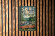 A vintage metal sign for Spirit Creek Forest in Georgia, featuring a scenic image of the forest and a waterfall.
