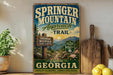 A vintage-style sign for the "Springer Mountain Approach Trail" in Georgia, featuring a scenic mountain landscape and trail marker.