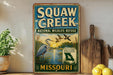 a vintage-style sign for Squaw Creek National Wildlife Refuge in Missouri, with a bird illustration and text promoting the refuge as a wildlife sanctuary.
