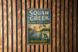 A vintage metal sign for Squaw Creek National Wildlife Refuge in Missouri, featuring an illustration of a bird and a body of water.