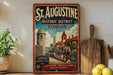 A vintage-style metal sign for St. Augustine, Florida, featuring a colorful illustration of the historic district with a castle, palm trees, and a body of water.