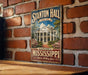 A vintage-style metal sign for Stanton Hall in Mississippi, featuring a large illustration of the historic building surrounded by trees and flowers.