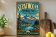 A vintage-style sign for Strathcona Provincial Park in British Columbia, Canada, featuring a scenic mountain landscape with a lake and pine trees.