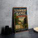 A vintage-style metal sign for the Strawberry Banke Museum in Portsmouth, New Hampshire, featuring an illustration of a historic street scene.
