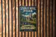 A vintage metal sign for Studley Royal Park, featuring an illustration of a castle and a bridge, mounted on a wooden wall.