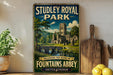 A vintage-style sign for Studley Royal Park, featuring an illustration of a castle and a bridge, with the text "Including the ruins of Fountains Abbey" and "United Kingdom" below.
