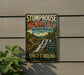 A vintage metal sign for Stumphouse Mountain Heritage Preserve, featuring a scenic image of a waterfall and a wooden cabin, mounted on a wall.