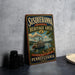 A vintage-style sign for Susquehanna National Heritage Area, featuring a steamboat and a scenic landscape, is displayed on a gray countertop next to some black camera lenses.