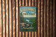 A vintage metal sign for Susquehannock State Forest in Pennsylvania, featuring a scenic landscape with a river and mountains.