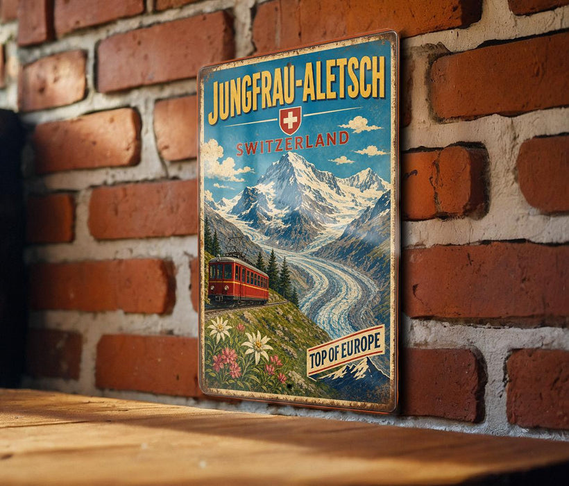 A vintage metal sign with a mountain landscape and a red train, mounted on a brick wall.