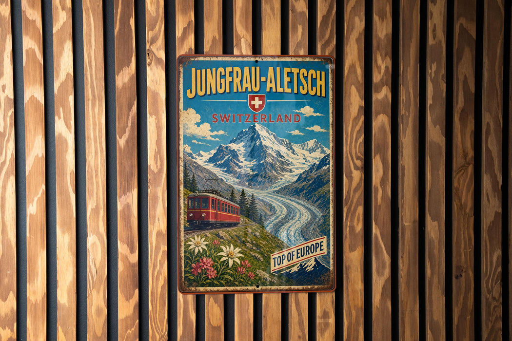 A vintage-style metal sign with a mountain landscape and a red train, mounted on a wooden wall.