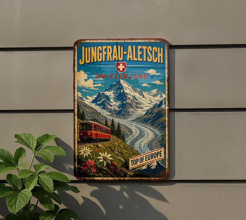 A vintage-style metal sign with a mountain landscape and a red train, mounted on a wall.