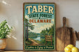 A vintage-style metal sign for Taber State Forest, Delaware, featuring a scenic landscape with a lake and pine trees.