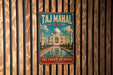 A vintage-style metal sign with the text "Taj Mahal India" and "The Crown of India" hangs on a wooden wall.