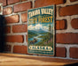 A vintage metal sign for Tanana Valley State Forest in Alaska, featuring a moose and a mountain landscape.