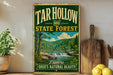 A vintage-style sign for the Tar Hollow State Forest in Ohio, featuring a scenic illustration of a forest landscape with a waterfall.