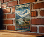 A vintage-style metal sign for Tatshenshini-Alsek Provincial Park in British Columbia, Canada, featuring a scenic mountain landscape with a moose in the foreground.