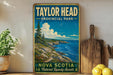 A vintage-style metal sign for Taylor Head Provincial Park in Nova Scotia, featuring a scenic coastal landscape with pine trees and a blue sky with clouds.