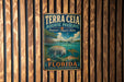 A vintage-style metal sign for Terra Ceia Aquatic Preserve, featuring an illustration of a manatee and other marine life, is displayed on a wooden wall.