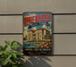 A vintage-style metal sign with the text "The Breakers" and "Rhode Island" is displayed on a wall, featuring an illustration of a building and a river.