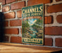 A vintage metal sign for the Channels State Forest in Virginia, featuring a scenic landscape with a river and trees.