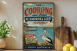 a vintage-style sign for "The Coorong and Lakes" in Australia, with a large illustration of a pelican and a scenic background.