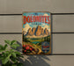 A vintage-style metal sign with the text "The Dolomites Italy" and a mountain landscape illustration, mounted on a wall.