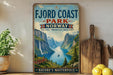 a vintage-style sign for Fjord Coast Park, Norway, with a scenic mountain landscape and a small boat on the water.