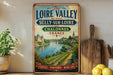 A vintage-style metal sign with a scenic image of the Loire Valley between Sully-sur-Loire and Chalonnes, France, featuring vineyards, castles, and a river.