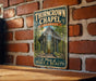 A vintage-style metal sign for the "Thorncrown Chapel" in Arkansas, featuring an illustration of the chapel surrounded by trees and a path leading up to the entrance.