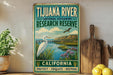 A vintage-style sign for the Tijuana River National Estuarine Research Reserve in California, featuring a white egret and a scenic landscape.