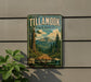 A vintage-style metal sign for Tillamook State Forest, featuring a scenic mountain landscape with pine trees and a dirt road.
