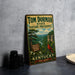 A vintage-style metal sign for Tom Dorman State Nature Preserve in Kentucky, featuring a scenic landscape with a red cardinal perched on a branch.