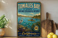 A vintage-style metal sign for the Tomales Bay State Marine Ecological Reserve in California, featuring a scenic illustration of a person kayaking in the bay.