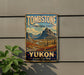 A vintage-style metal sign for Tombstone Territorial Park, Yukon, Canada, featuring a scenic mountain landscape.