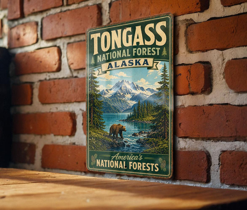 A vintage-style metal sign for Tongass National Forest in Alaska, featuring a scenic landscape with a bear and mountains in the background.