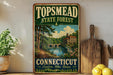 A vintage-style sign for the Topmead State Forest in Connecticut, featuring a scenic landscape with a river, bridge, and trees.