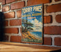 A vintage-style metal sign for Torrey Pines State Natural Reserve in California, featuring a scenic image of a coastal landscape with a tree and ocean.