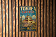 A vintage-style metal sign for Tovrea Castle, a desert treasure in Arizona, is displayed on a wooden wall.