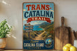 A vintage-style sign for the Trans-Catalina Trail in Catalina Island, California, featuring a scenic mountain landscape and a trail sign.