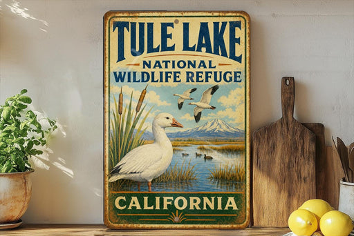 A vintage-style metal sign for Tule Lake National Wildlife Refuge in California, featuring an illustration of a duck and a mountain landscape.