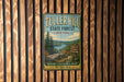 A vintage metal sign for Tuller Hill State Forest in New York, featuring a scenic landscape with a lake and mountains.