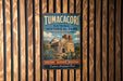 A vintage metal sign for Tumacori National Historical Park in Arizona, featuring an illustration of a historic building surrounded by desert vegetation.